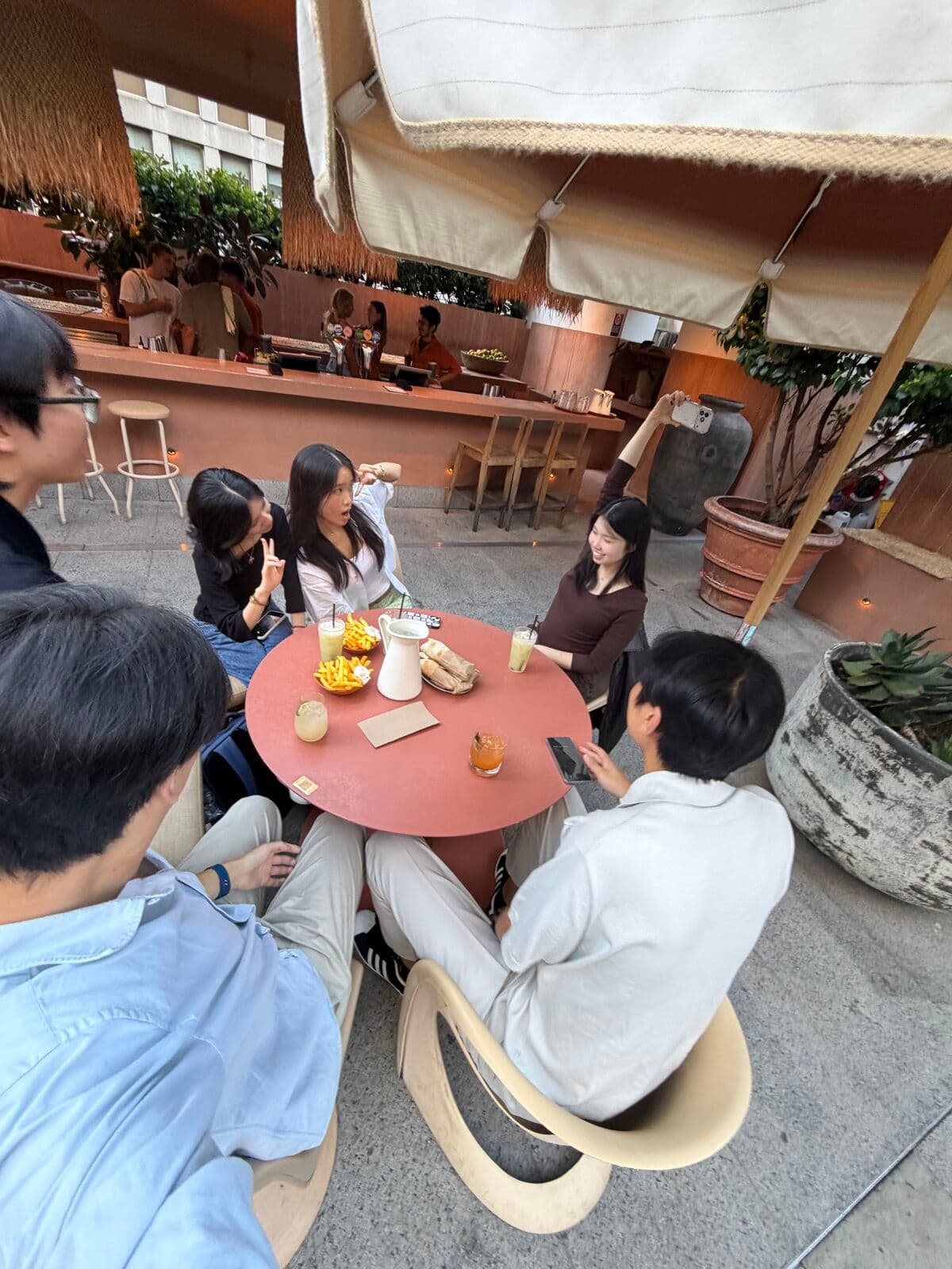Friends around a small round table at an outdoor café